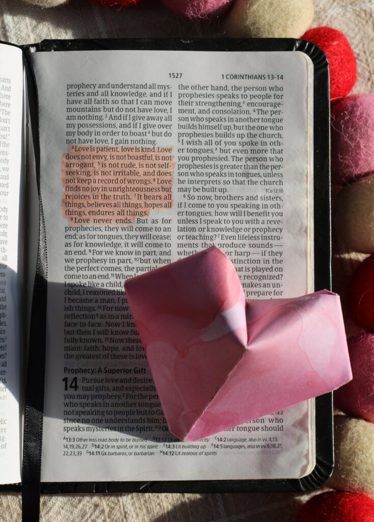 bible open to 1 corinthians 13 with paper heart