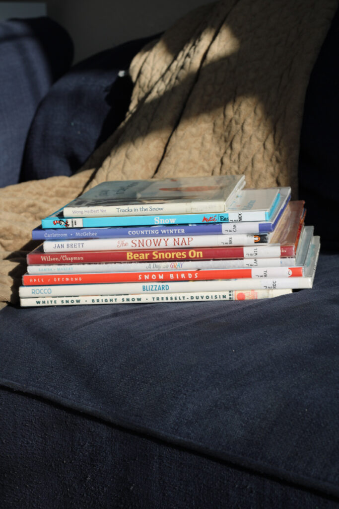 stack of winter themed picture books on a couch